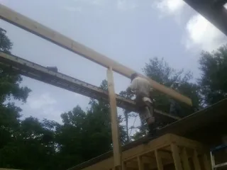 Carpenter setting a ridge beam over a new addition frame — Ice Dam Removal by Roofing Brothers in Woodbridge