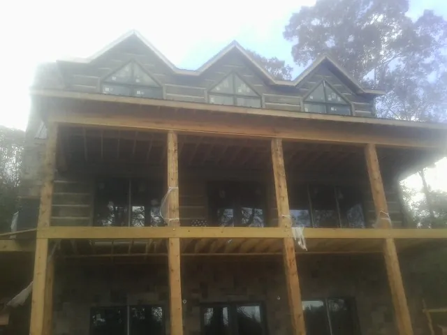 Dormers and porch framing on a large log home under construction — Roof Coating work by our crew in Woodbridge